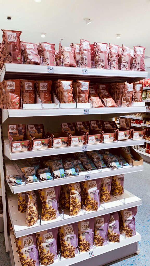 An organized display of assorted snack bags on grocery store shelves.